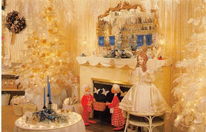 Postcard image of the defunct Rogers' Christmas House in Brooksville, Florida, featuring a lavishly decorated holiday-themed room. The scene showcases intricately adorned Christmas trees, a fireplace with festive mantel decorations, and mannequins dressed in holiday attire. Once a beloved attraction in Brooksville, this iconic Christmas house holds historical significance and remains a memorable piece of Florida's festive past.